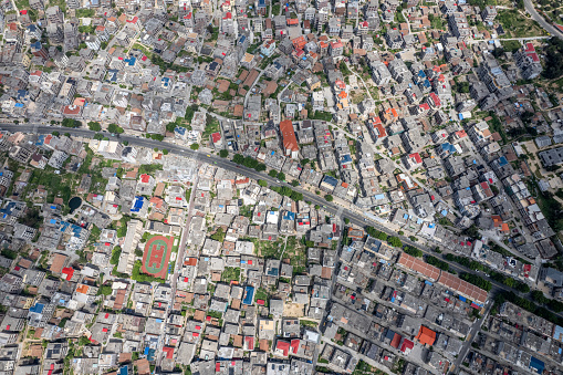 Vertical aerial view of densely populated urban houses and greenery