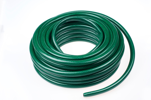 Plastic green hose-pipe on white bachground