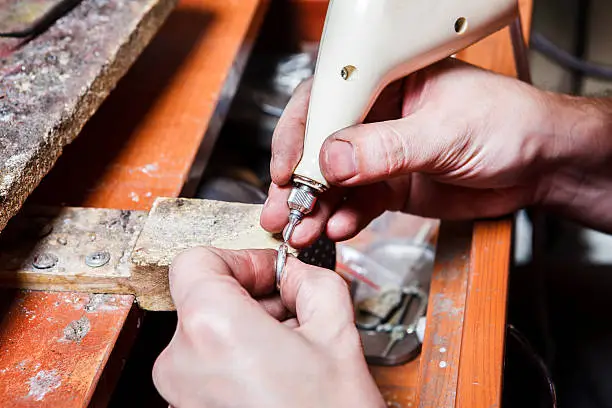 Jeweler's hands engraving on the ring