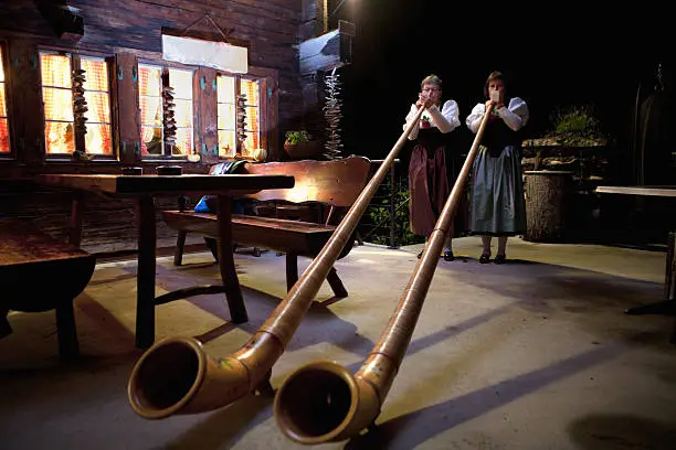 Two women playing the alpenhorns in Switzerland. Low light, long exposure. Lenk Lypse 2012.