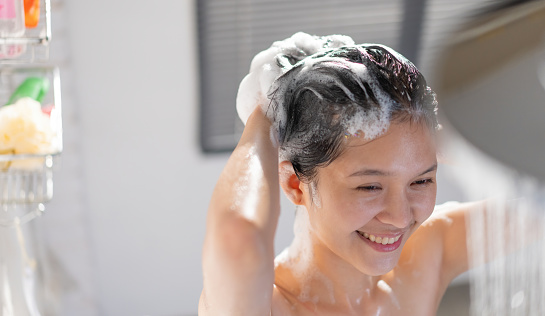Asian young woman having fun while showering She's washed her hair.