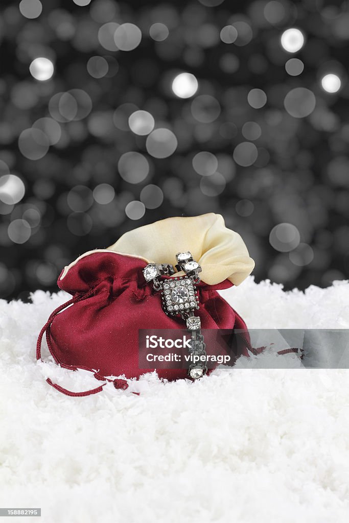 Silver bracelet draped on red satin pouch in snow  http://www.microstock.gr/istock/christmas.jpg Diamond - Gemstone Stock Photo