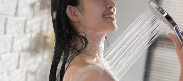 istock female Asian taking joy in the shower and using soap She feels at rest. 1588827868