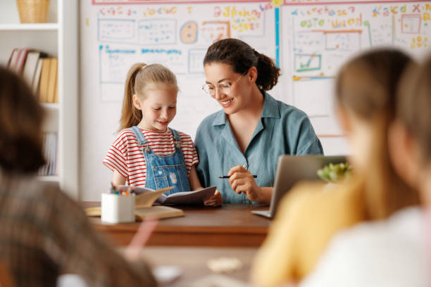 istock Happy kids and teacher at school 1588876685