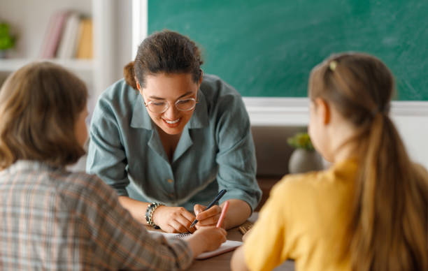 istock Happy kids and teacher at school 1588877194