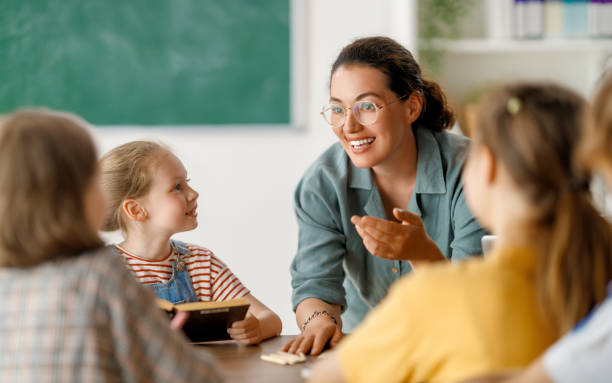 istock Happy kids and teacher at school 1588878097