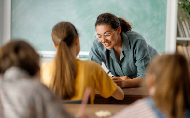 istock Happy kids and teacher at school 1588878221
