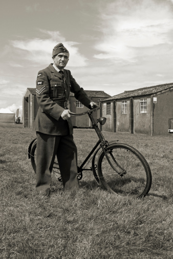 WW2 RAF Ground crew member with his bike at RAF base during the Battle of Britain.Picture has been aged to give the feel of a Vintage photograph.Re-enactor.