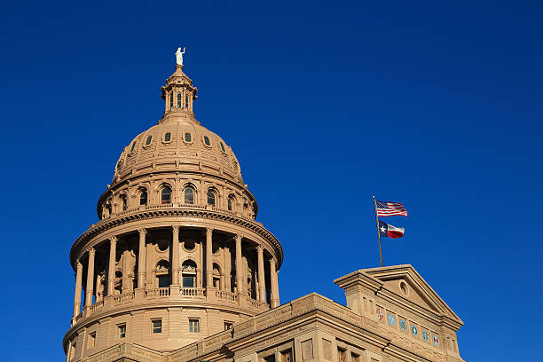 istock Texas State Capitol with a flag on a clear blue sky 158894771