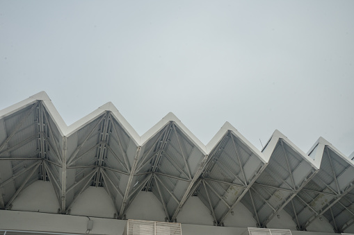 Roof building zigzag line repetition on hazy cloud architecture construction closeup detail