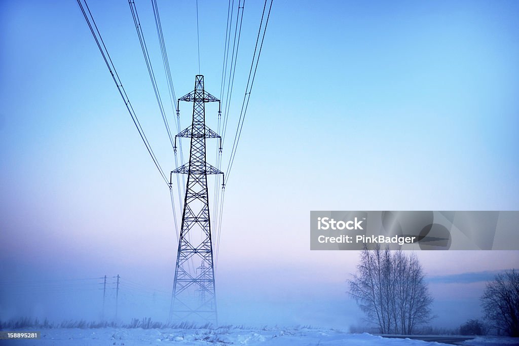 Electricity pylon in fog Electricity pylon in heavy fog at sunset in winter Blue Stock Photo