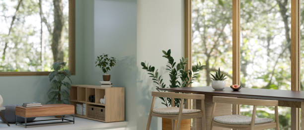 istock Minimal and comfortable living room with a table against the large glass window 1588962202