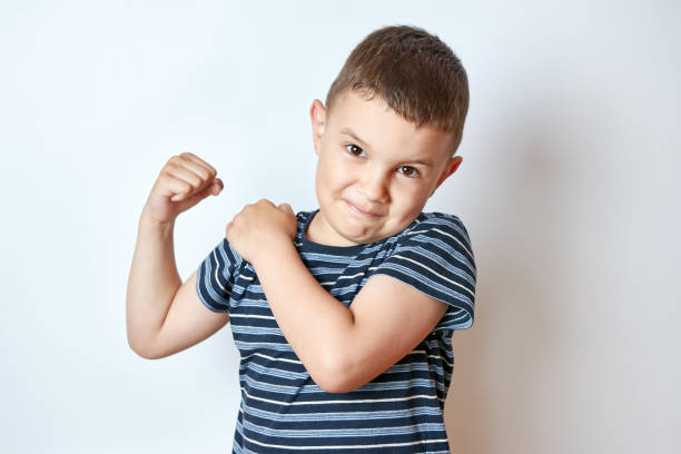 istock Handsome little boy shows body muscles. Children's antics. 1588975756