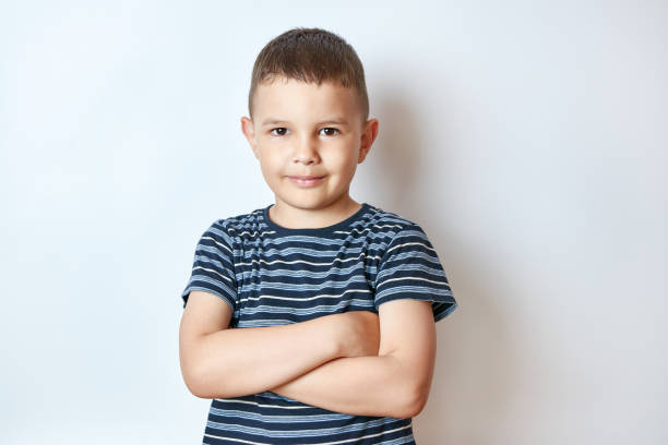 istock Little smiling boy posing with folded arms. 1588975766