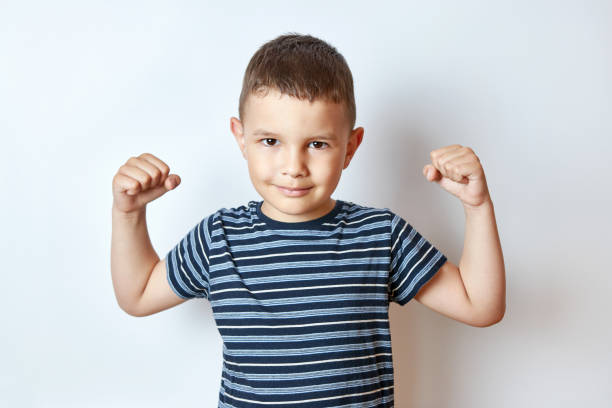 istock Handsome little boy shows body muscles. Children's antics. 1588975767