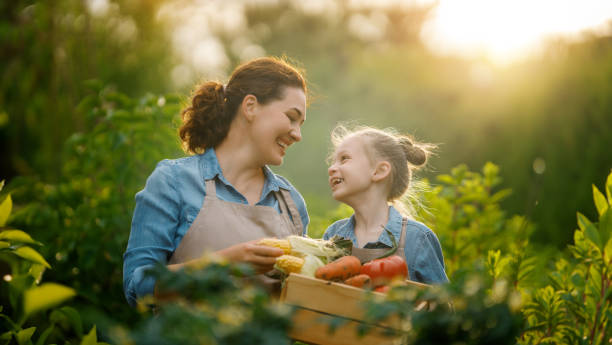 mother and daughter gardening in the backyard stock photo