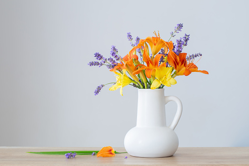 summer flowers in white jug on wooden shelf