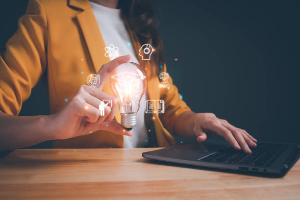 istock Woman holding lightbulb showing graduation hat. online education, digital courses to develop new skills, e-learning webinar on internet for personal development, Internet education course degree. 1589093336
