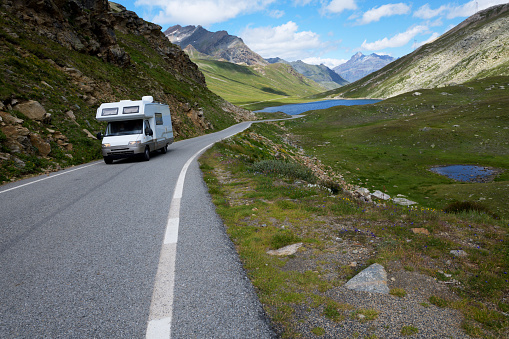 A motorhome or RV recreational vehicle road trip vacation. Driving on the highway of Dolomites, European Alps.