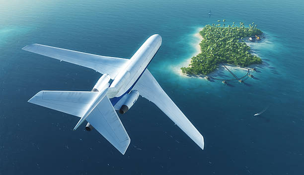 Passenger plane flies over paradise tropical island stock photo