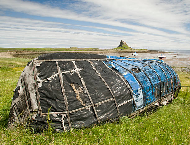 Blue upturned boat with Lindesfarne Castle stock photo