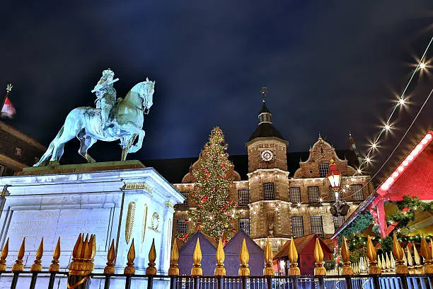 Jan Wellem statue on the Dusseldorf Christmas Market with a giant Christmas tree and the historic city hall as a backdrop
