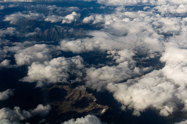 Aerial View of a Cloudscape and barren mountains below.