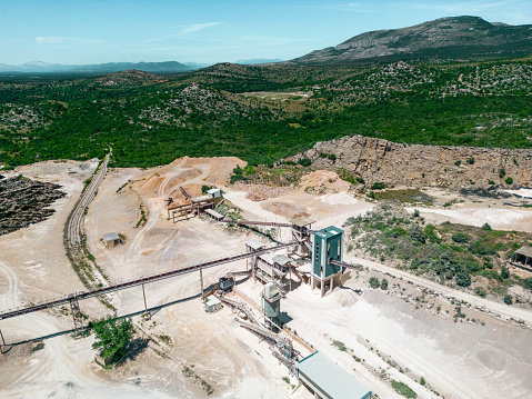 Aerial view of crushed stone quarry machine. Producing of construction materials at open pit limestone mine. Stone crushing plant. Cone type rock crusher