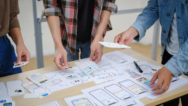 istock Group of young creative people working on new website wireframe, planning application development at office. 1589153319