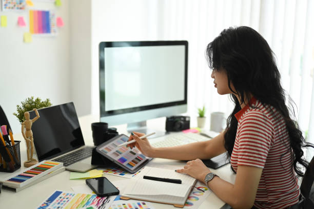 istock Young creative woman working with color palette, choosing color samples for design project at graphic studio. 1589155407