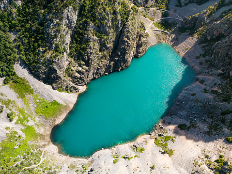 Scenic aerial view of Imotski Blue Lake (Modro jezero) in limestone crater, Dalmatia, Croatia. Nature summer landscape, popular tourist attraction, outdoor travel background.