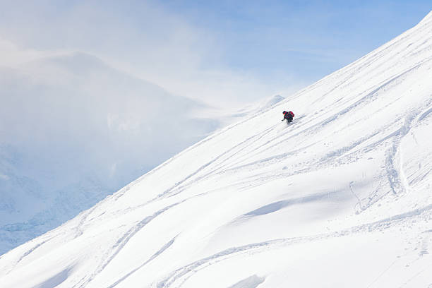 Backcountry skier on a wide open slope stock photo