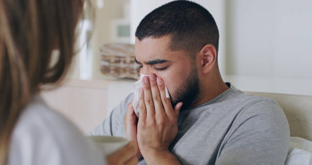 nariz assoado, doente e cuidados com casal no quarto para doença, saúde e doença. vírus, fadiga e preocupação com homem e mulher na cama em casa para tratamento de espirros, febre e bem-estar - cold and flu flu virus bed couple - fotografias e filmes do acervo