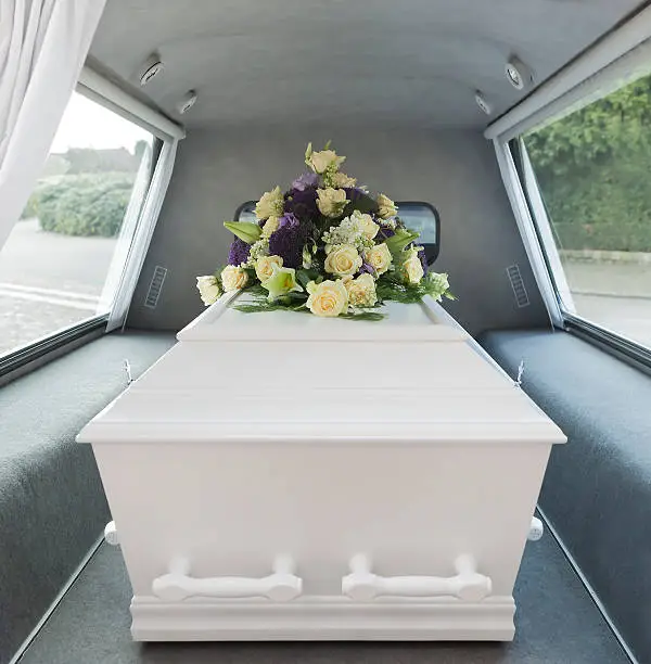 A casket in the back of an open hearse