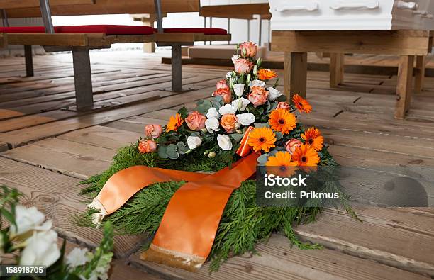 Orange And White Flower Wreath Laid Next To A White Casket Stock Photo - Download Image Now