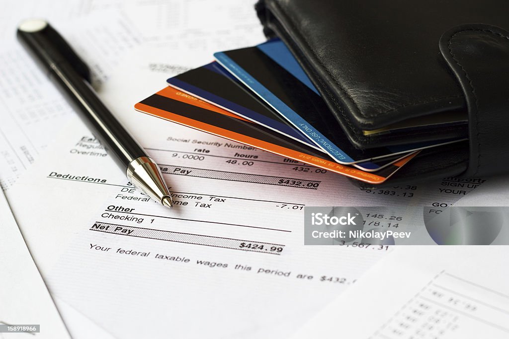 Personal finances Close up image of a paycheck, pay statements, wallet, credit cards. Business Stock Photo