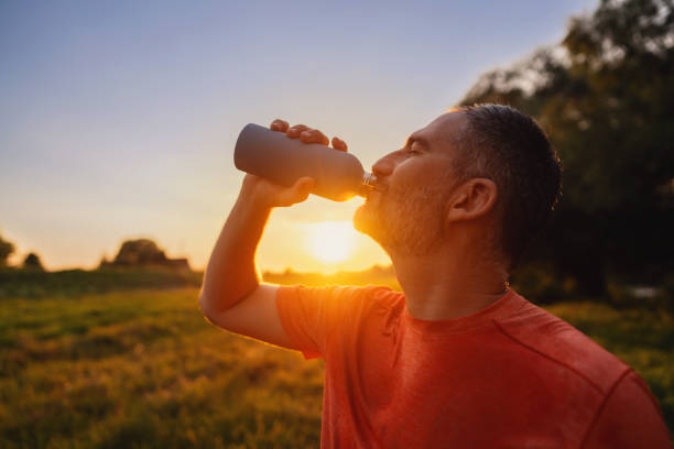 istock Man drinking water from his water bottle after jogging 1589193069