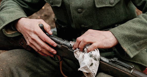 World War II German Soldier Cleaning Rifle. Soldier Preparing Weapon. German Military Ammunition Of A German WW2 Soldier.