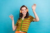 Photo of careless youngster girl listen favorite music playlist youtube itunes app headphones dance isolated on blue color background
