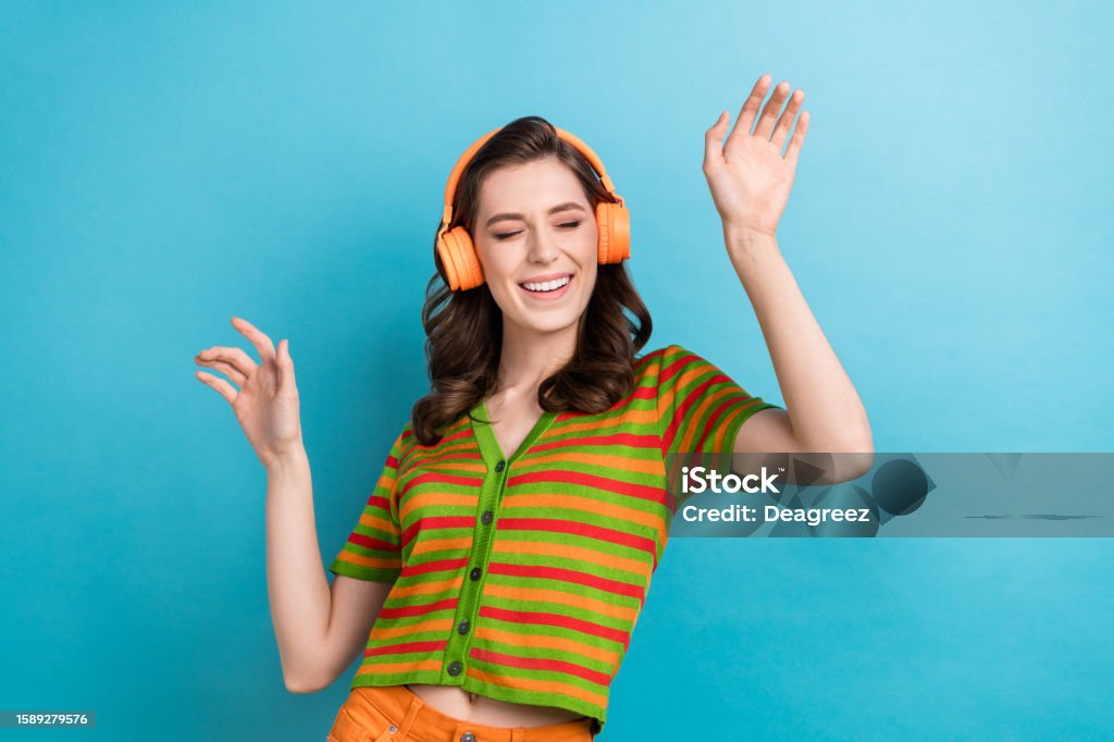 Photo of careless youngster girl listen favorite music playlist youtube itunes app headphones dance isolated on blue color background Photo of careless youngster girl listen favorite music playlist youtube itunes app headphones dance isolated on blue color background. 18-19 Years Stock Photo