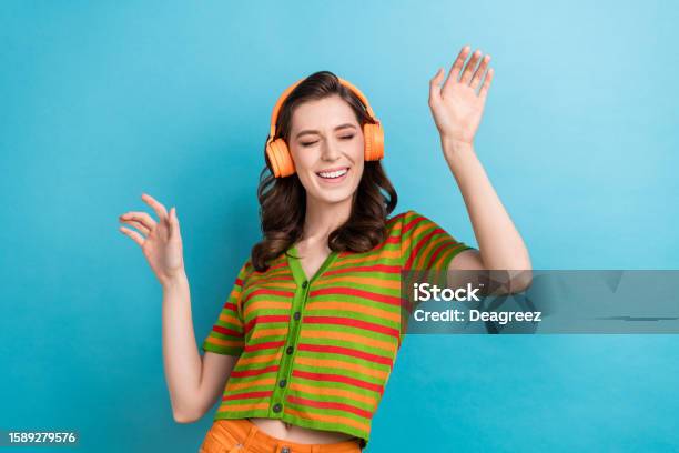 Photo Of Careless Youngster Girl Listen Favorite Music Playlist Youtube Itunes App Headphones Dance Isolated On Blue Color Background Stock Photo - Download Image Now