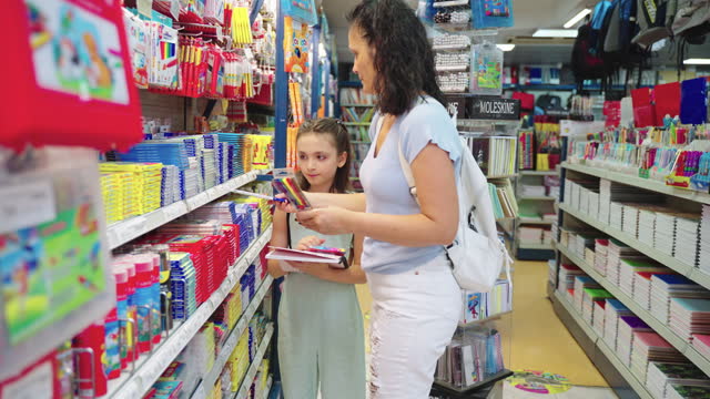 Mother and daughter shopping school supplies in a store
