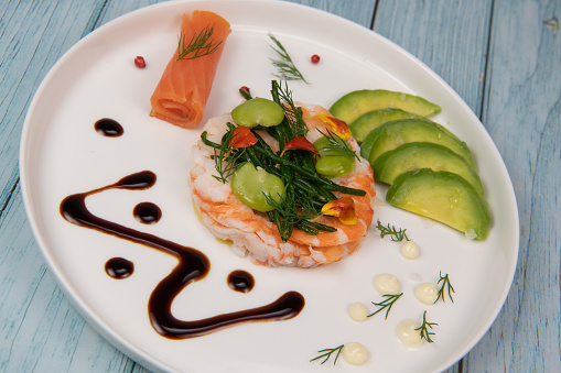 Recipe Fish Appetizer shrimp carpaccio, smoked salmon, avocado, samphire, broad beans, lemon sauce, olive oil, served with mayonnaise in white round plate, High quality photo