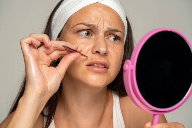 a young woman plucks her upper lip with a tuft