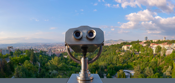 Blue tourist monocular with a beautiful mediterranean landscape in the background on a sunny summer day. Copy space for text.  Selective focus  \