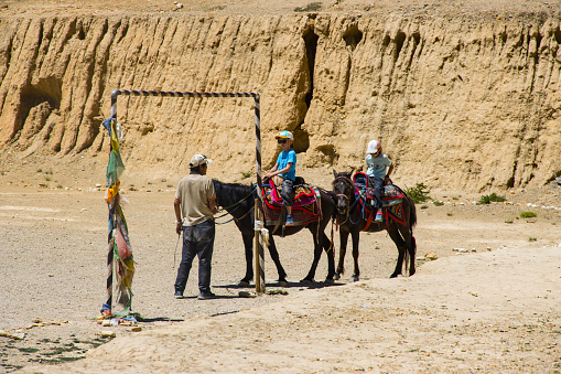 Tourist Children riding Horse in Chhoser Cave of  Upper Mustang Nepal