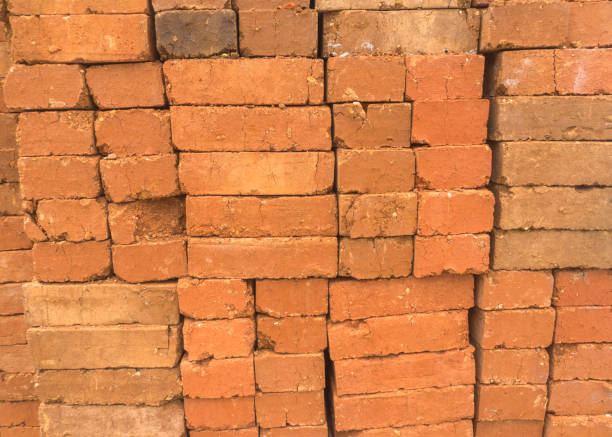 istock Stack of clay Brown brick for wall construction detail background closeup 1589329943