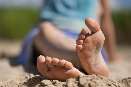 Only young woman sitting on the beach. A lake in south-eastern Poland.