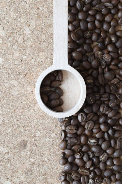 istock Coffee bean with wooden coffee spoon art on cork board. Flat lay, top down. 1589356610
