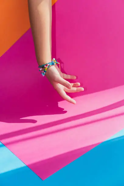 Photo of Palm hand with jewelry bracelet accessories on colorful background in beauty and fashion style